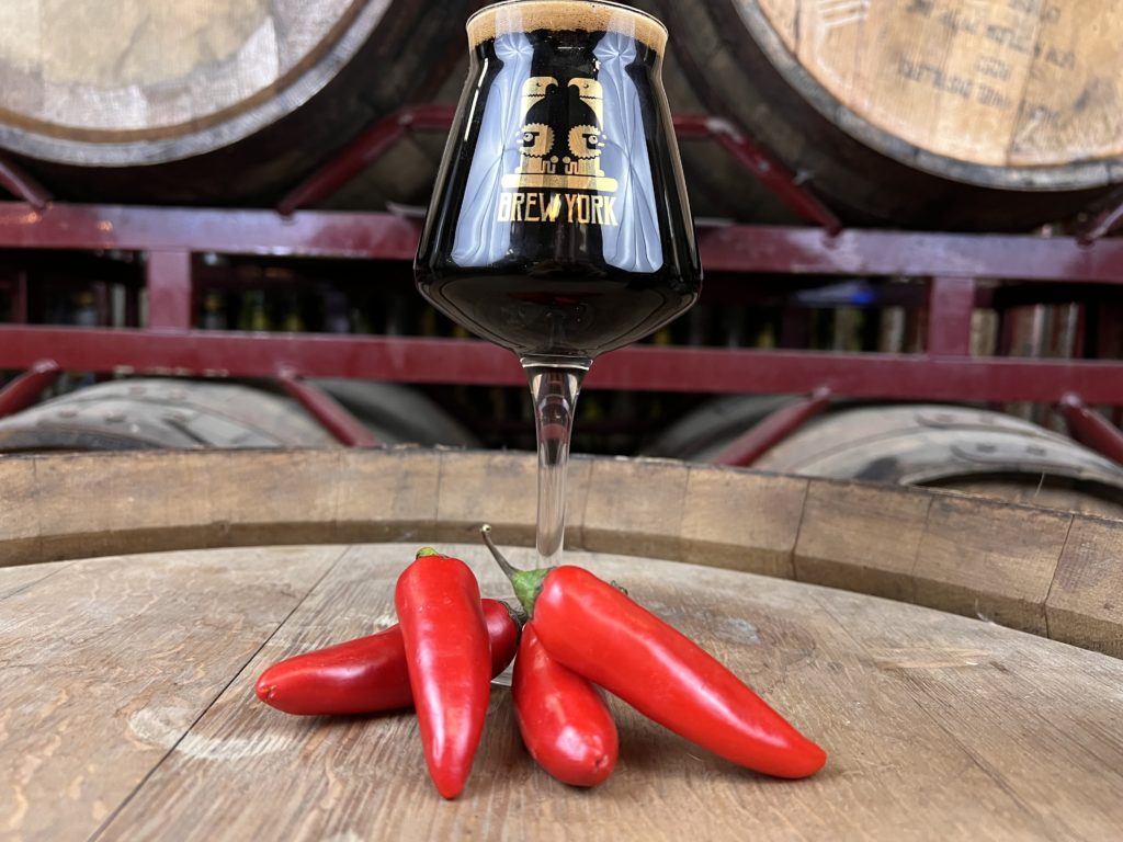 Glass of dark beer with red chillies